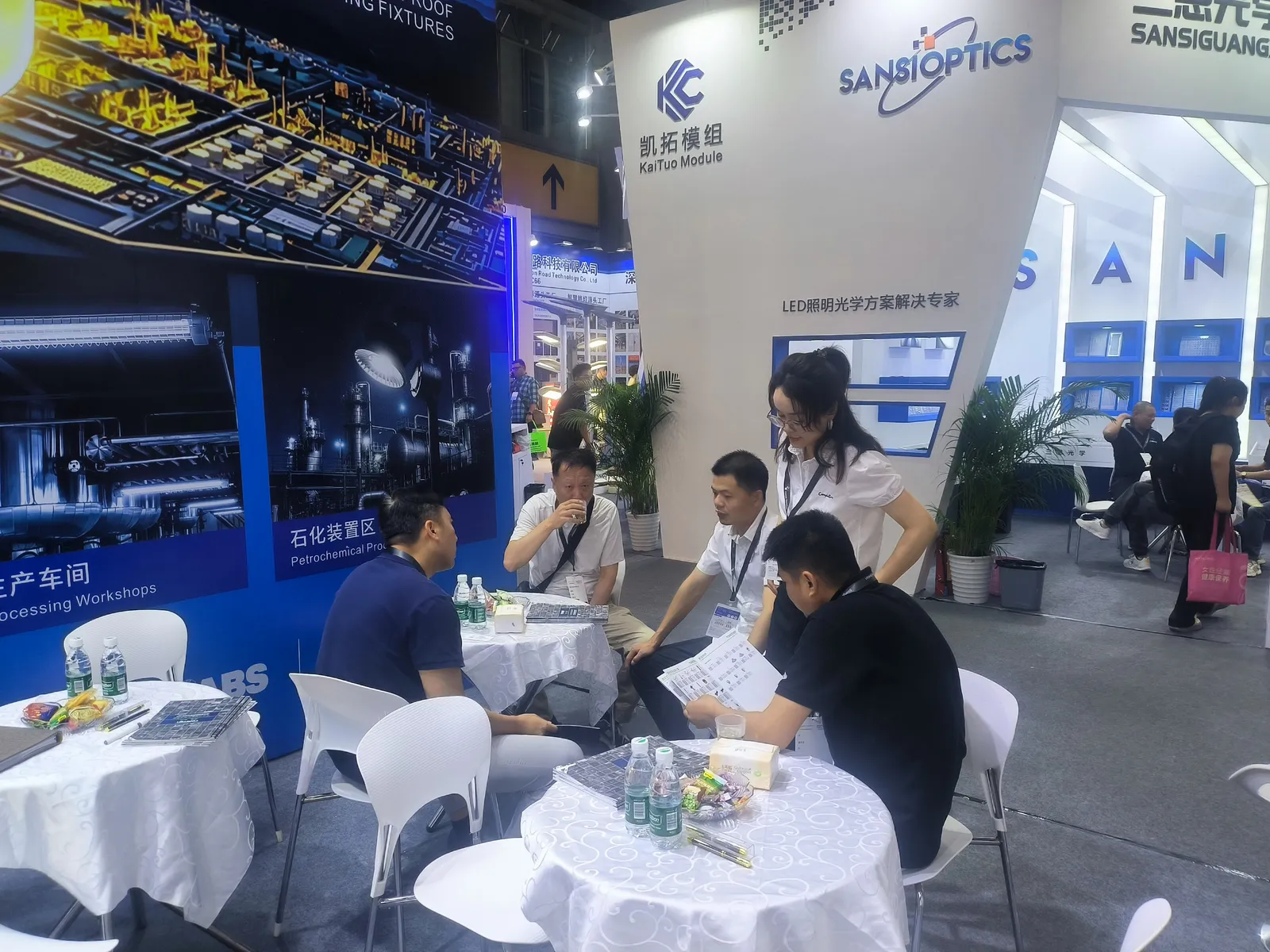 Visitors and team members seated beside the lighting display at GILE 2026.